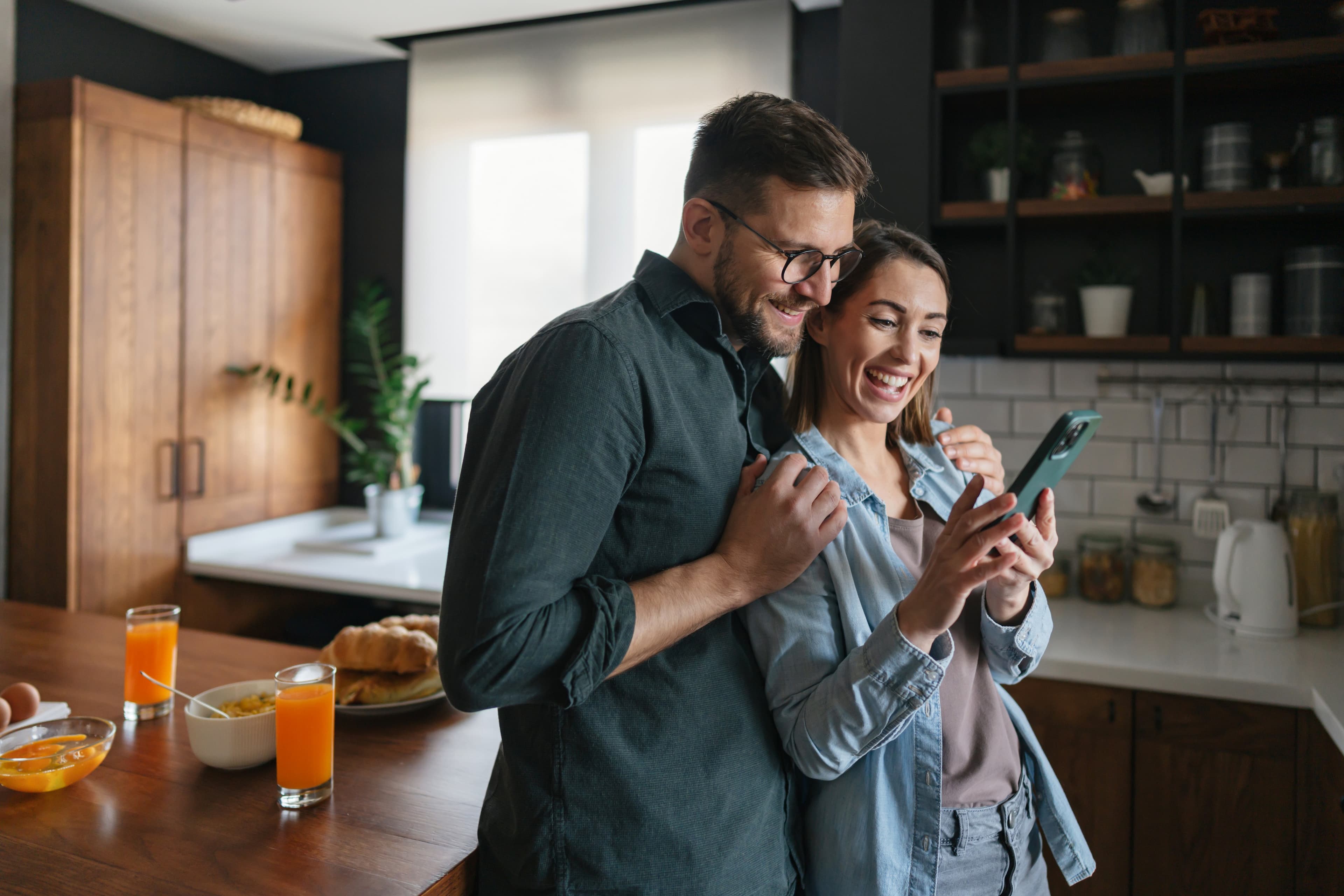 Couple looking at phone excited about home listings